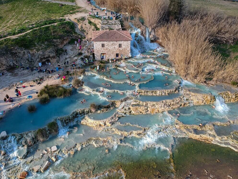 Cascate del Mulino hot spring waterfalls flowing over white travertine in Saturnia Italy, illustrating Italy's natural thermal heritage