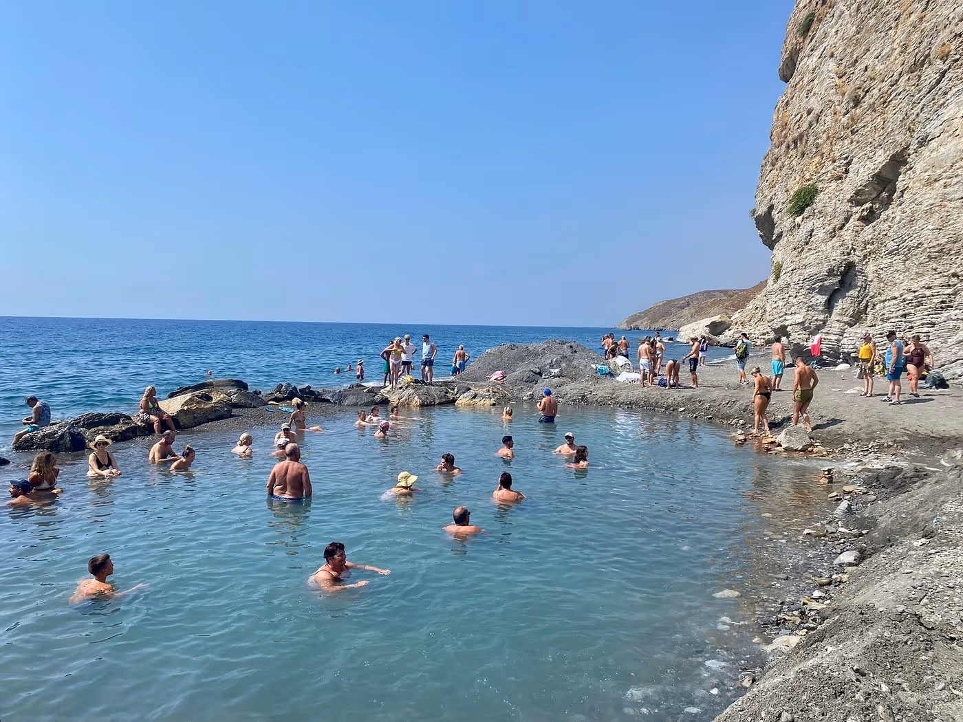 Beach goers soaking in thermal pool on  Therma Beach Hot Springs (Embros Thermae), Greece