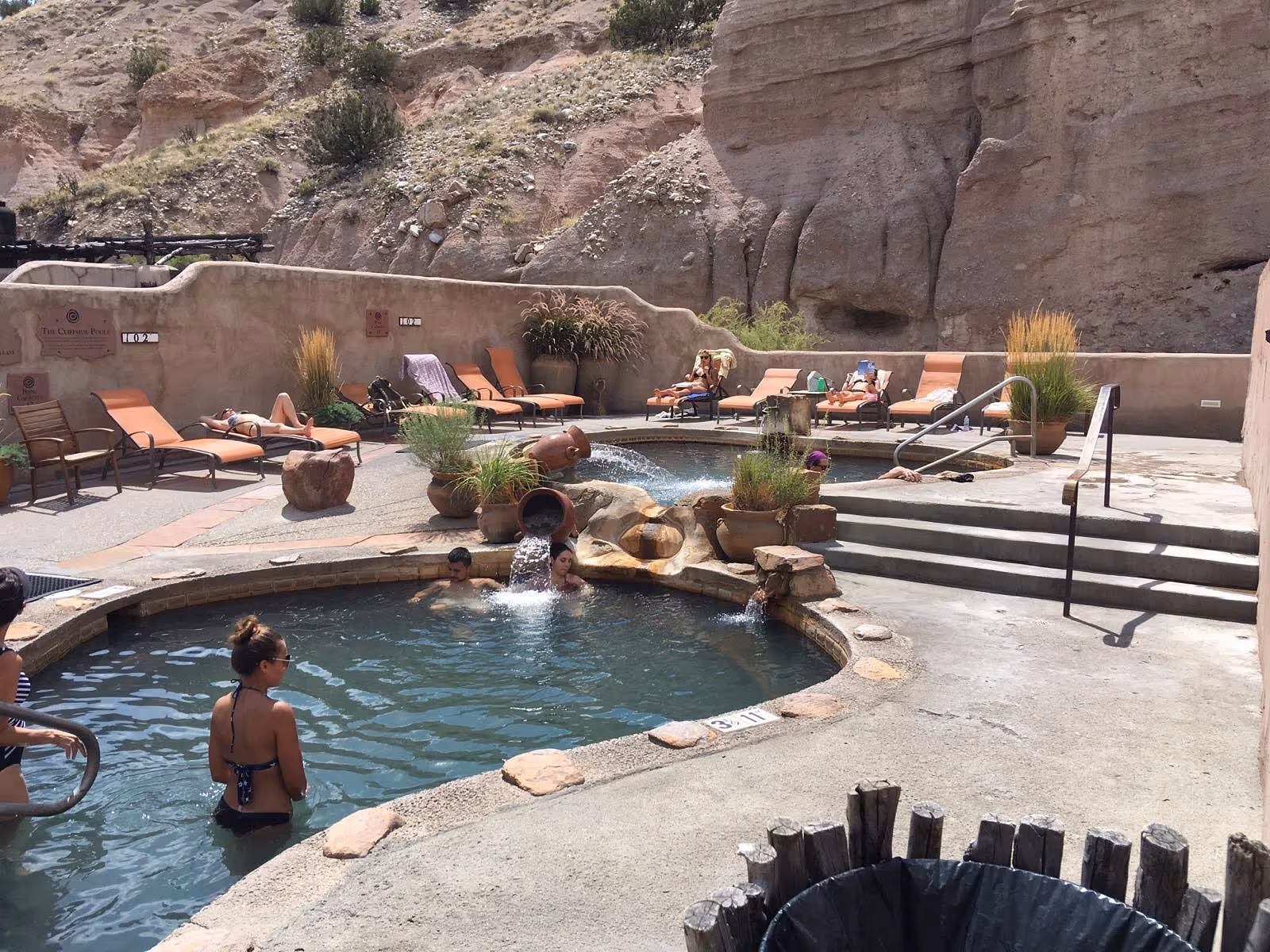 People soaking in a hot spring in desert setting in Ojo Caliente Mineral Springs, New Mexico