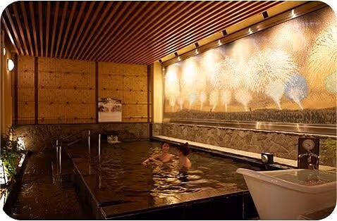 People soaking in dim light onsen Thermae-Yu, Japan