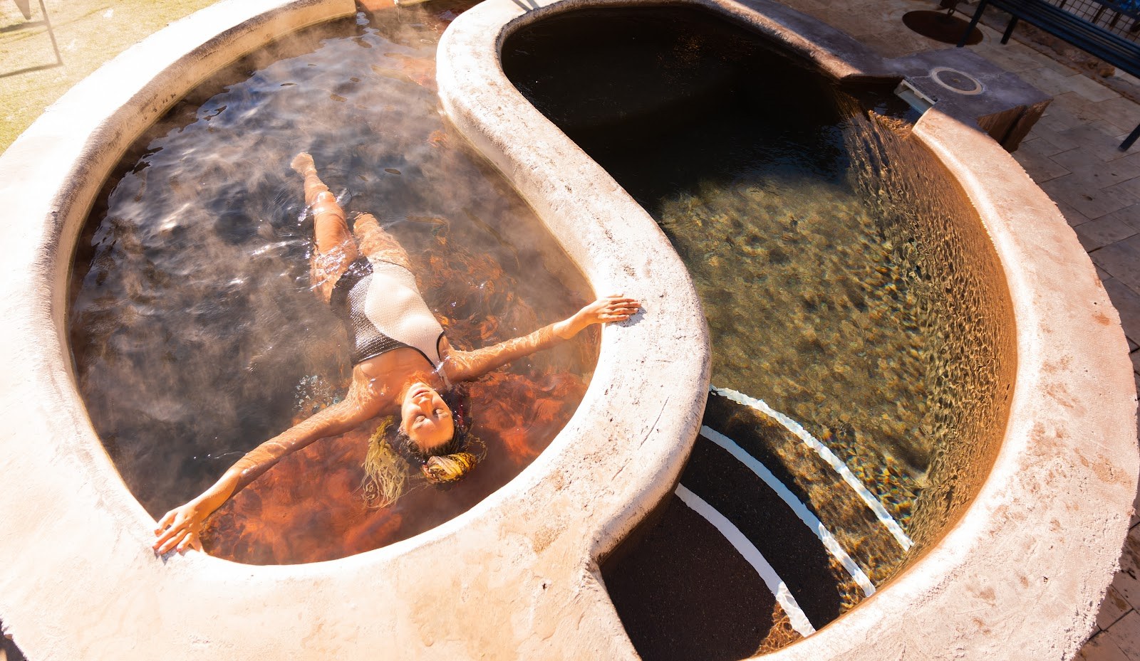 Woman relaxing in steaming dual-temperature soaking pools at Durango Hot Springs located in Durango, Colorado, United States.