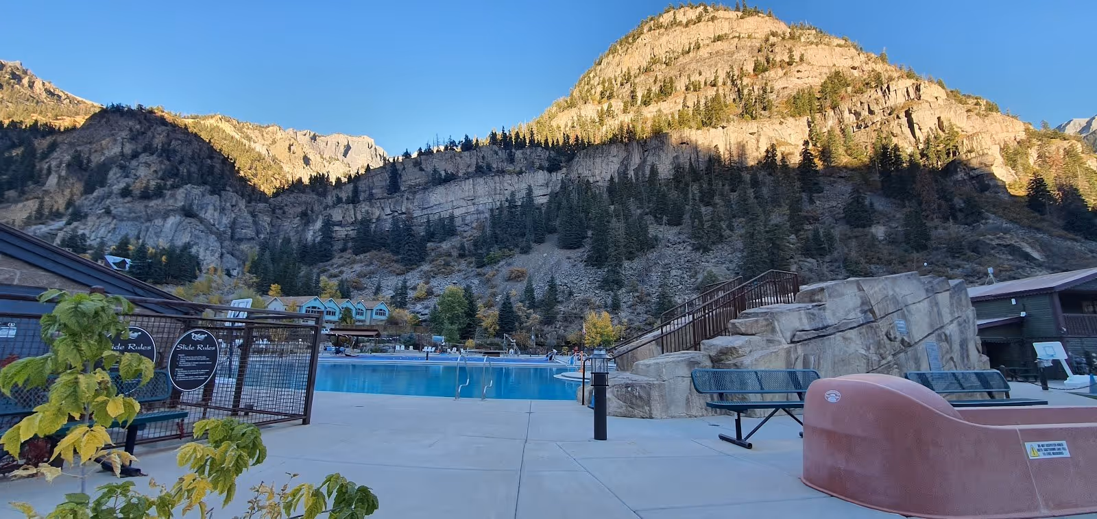 Ouray Hot Springs Pool in Colorado with a large clear outdoor pool and mountainous backdrop during late afternoon light.