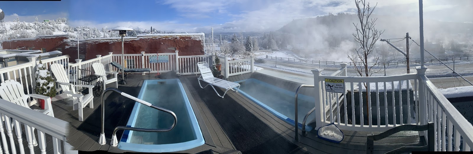 Outdoor steaming pools at Overlook Hot Springs Spa with snowy surroundings and seating in Pagosa Springs, Colorado.