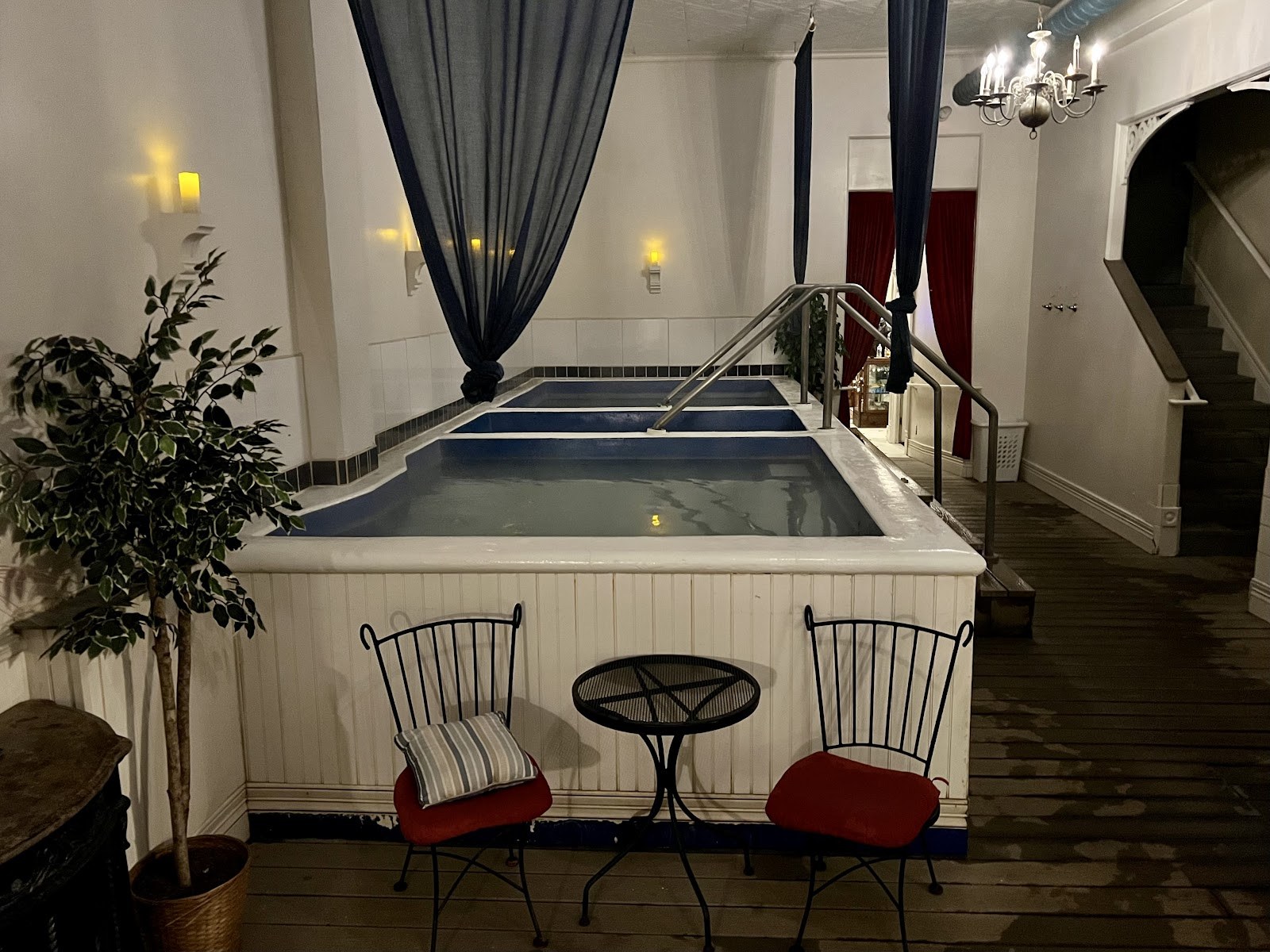 Three indoor hot spring pools with handrails and cozy seating area inside Overlook Hot Springs Spa in Pagosa Springs, Colorado.