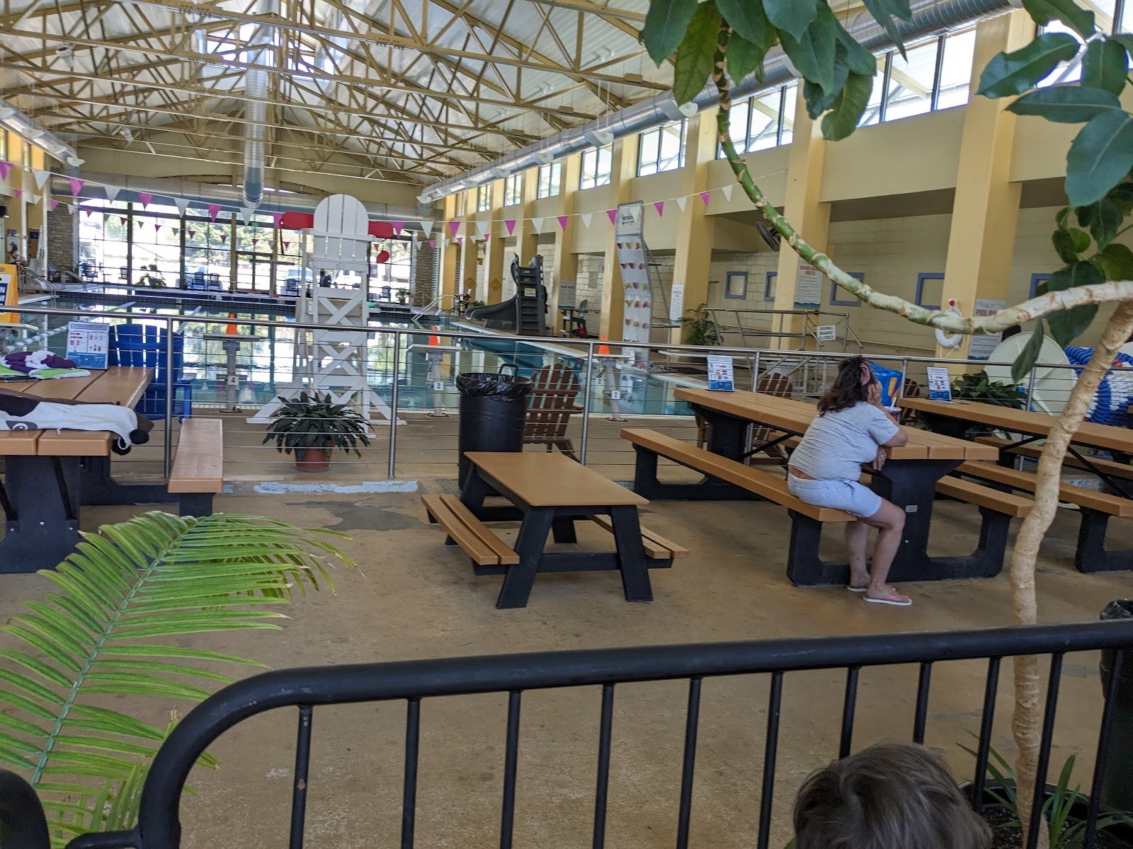 Indoor pool and seating area at Salida Hot Springs Aquatic Center in Salida, Colorado, with picnic benches and large windows.