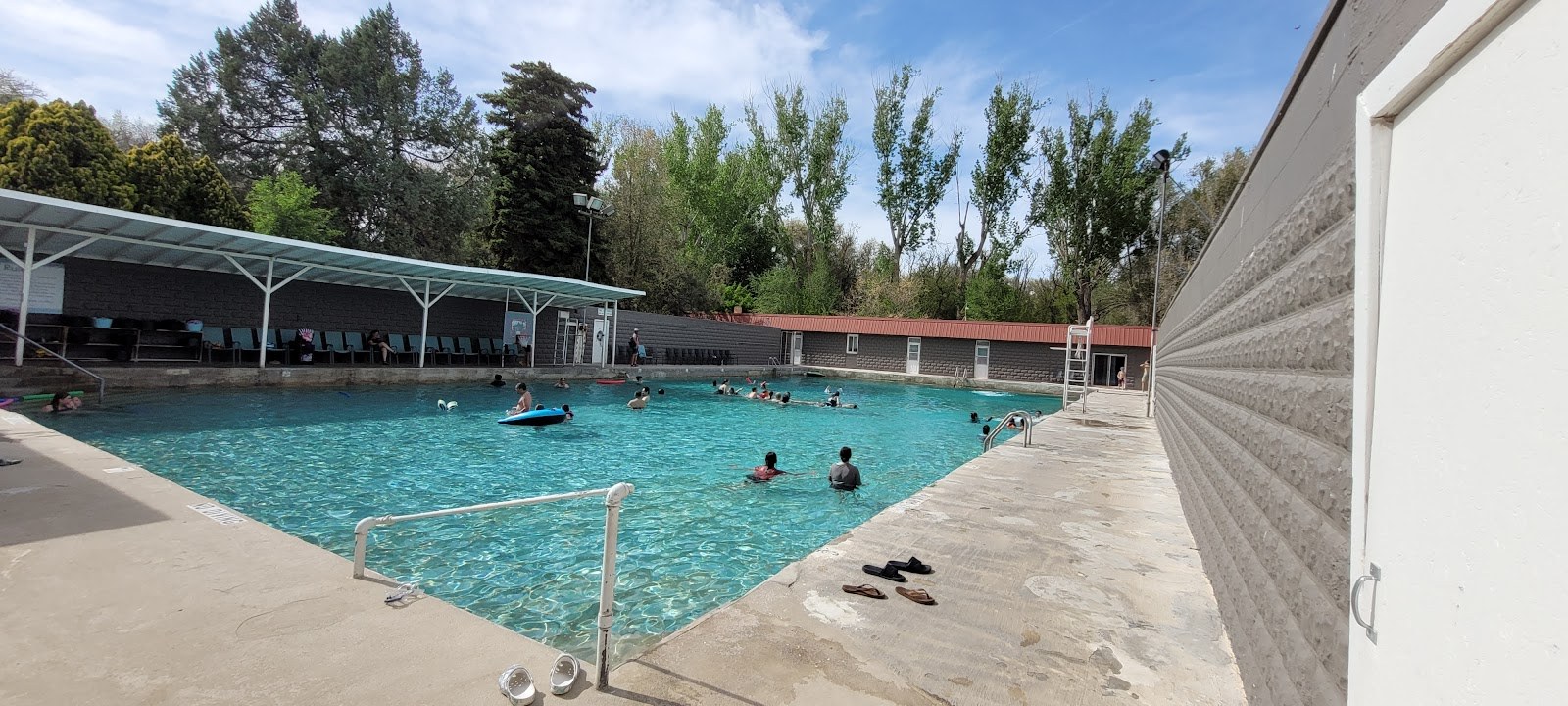 Daylight scene of Banbury Hot Springs outdoor pool with several visitors enjoying the water near Buhl, Idaho, United States