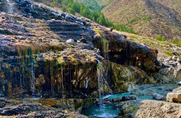 Natural hot spring waterfall cascading over rugged rocks at Mile 16 Hot Springs in the mountainous area near Cascade, Idaho.