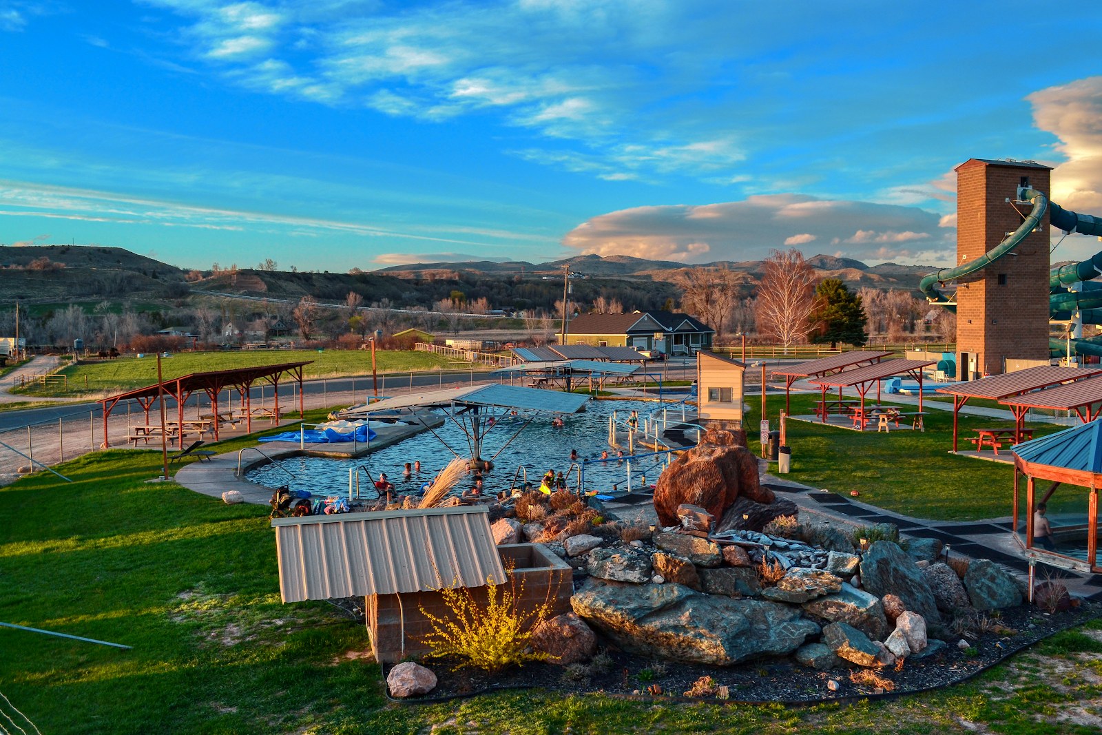 Scenic view of Riverdale Resort Hot Springs in Idaho, showing the hot spring pool surrounded by green grass and picnic areas.