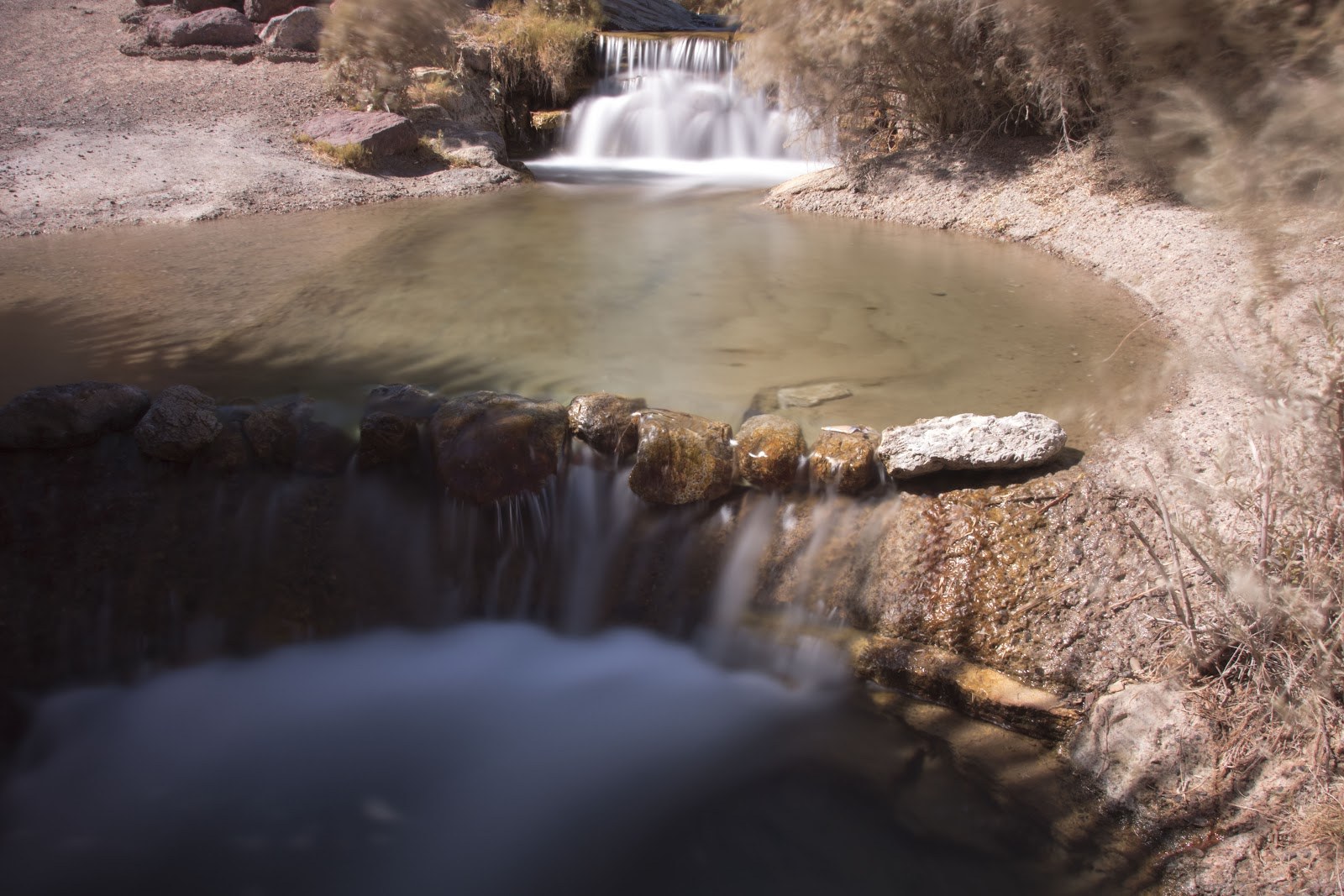 View of Rogers Spring in Nevada showing a natural hot spring pool with cascading rock waterfalls near Overton, United States
