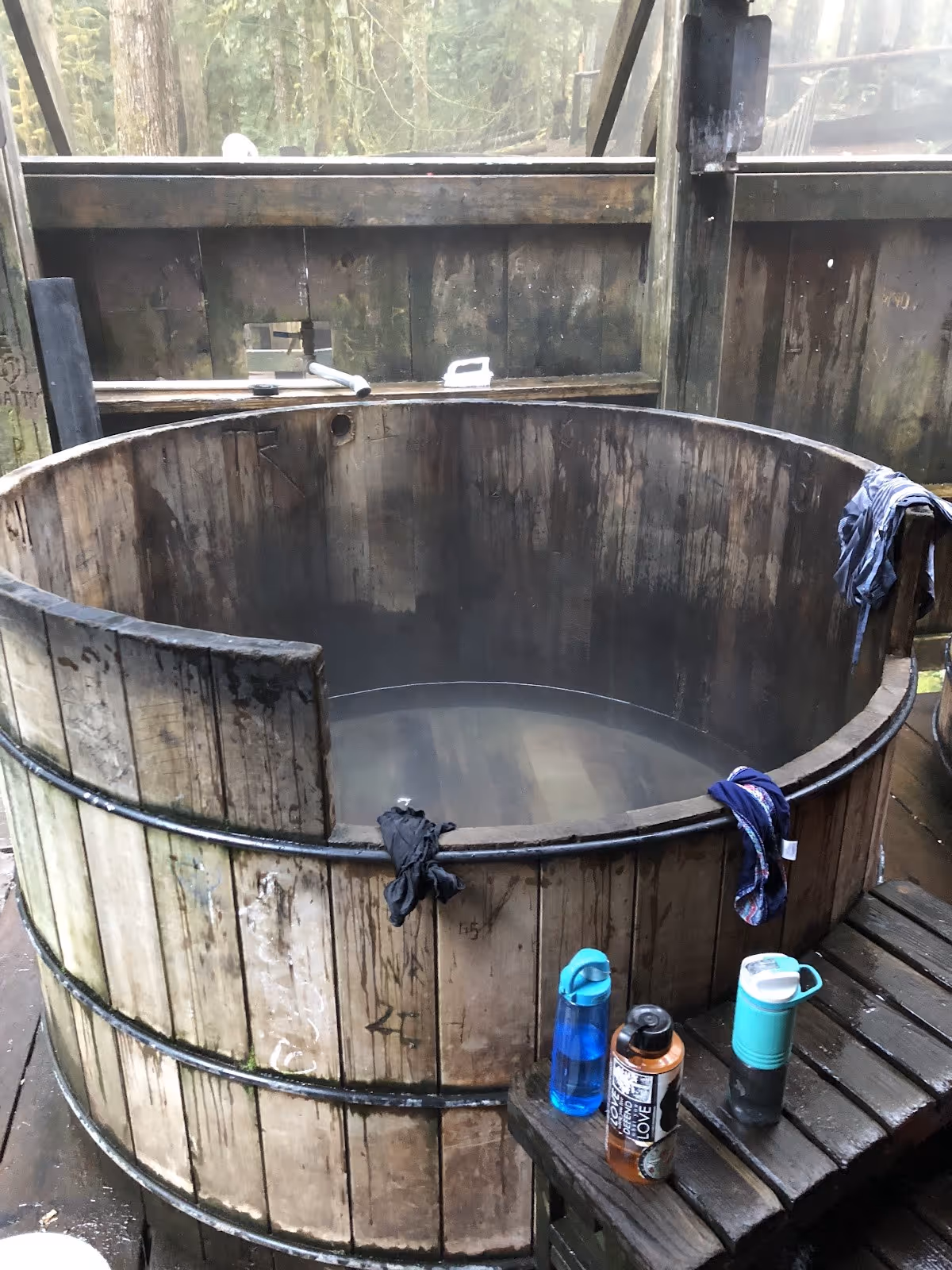 Wooden soaking tub with steam rising inside a rustic enclosure at Bagby Hot Springs near Estacada Oregon.