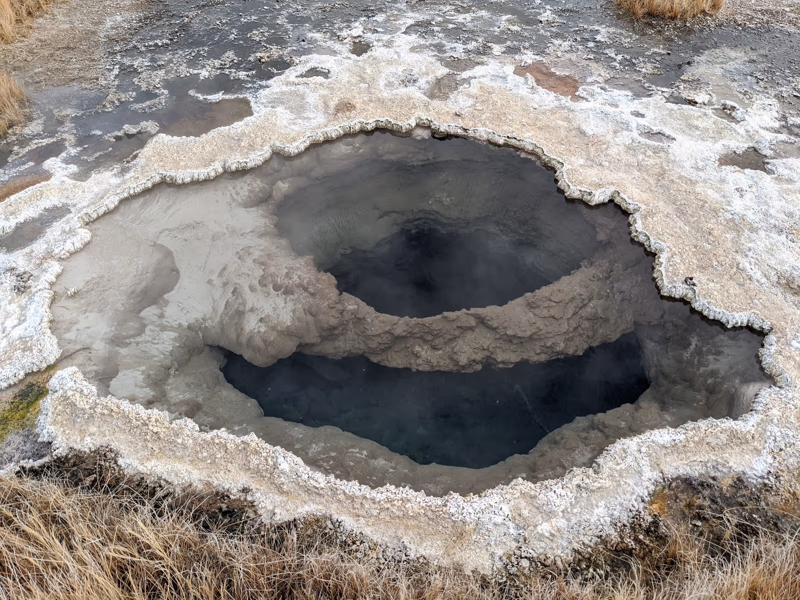 A hot spring vent pool with mineral deposits around its edges bubbling with steam at Borax Hot Springs near Fields, Oregon.
