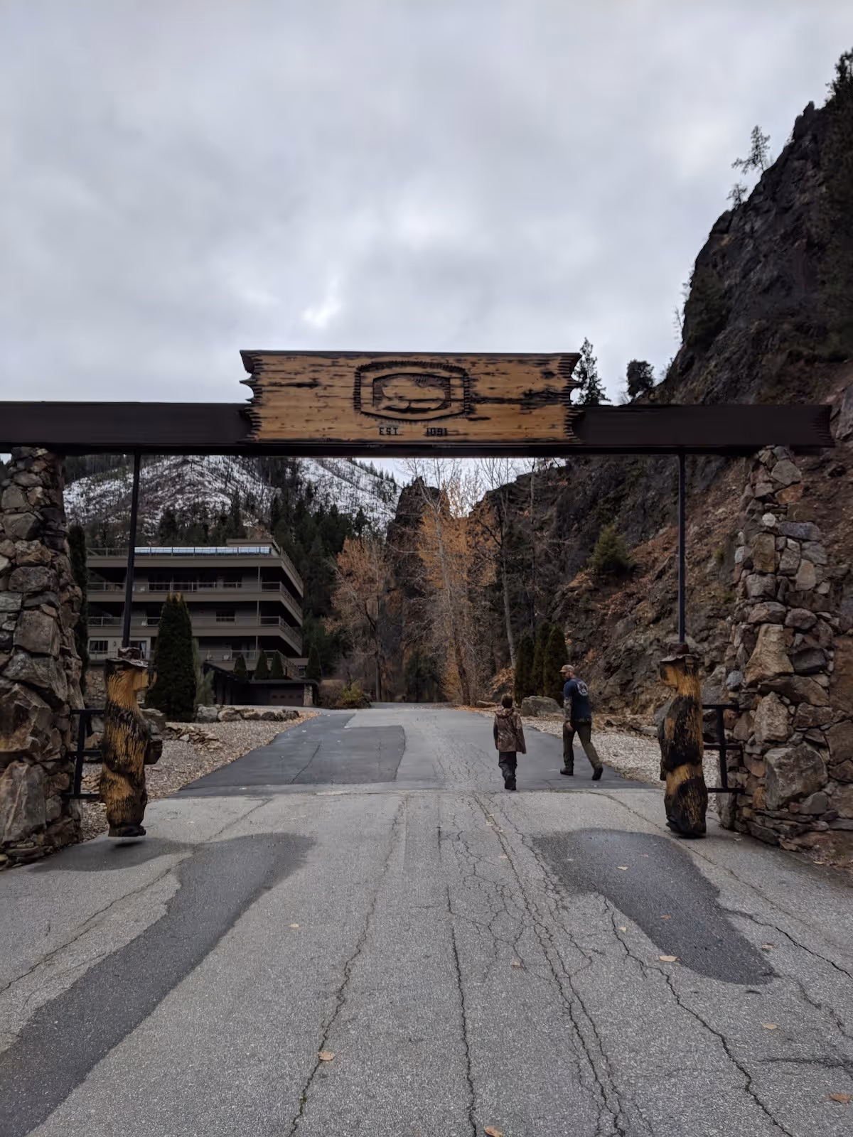 Wooden entrance sign gate with carved bear statues welcomes visitors to Sleeping Child Hot Springs in Hamilton Montana.