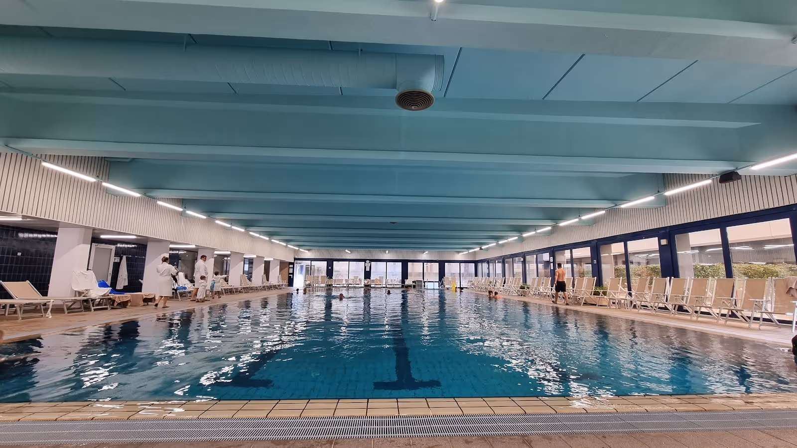 Indoor pool with calm water and numerous lounge chairs along the sides at Interhotel Sandanski Thermal Pools in Sandanski, Bulgaria.