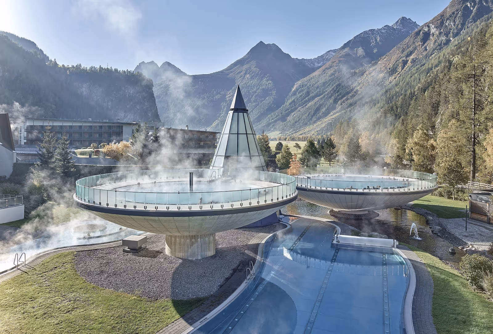 Two large steaming outdoor spa pools shaped like bowls at Aqua Dome Tirol Therme Längenfeld, surrounded by mountains near Langenfeld, Austr.