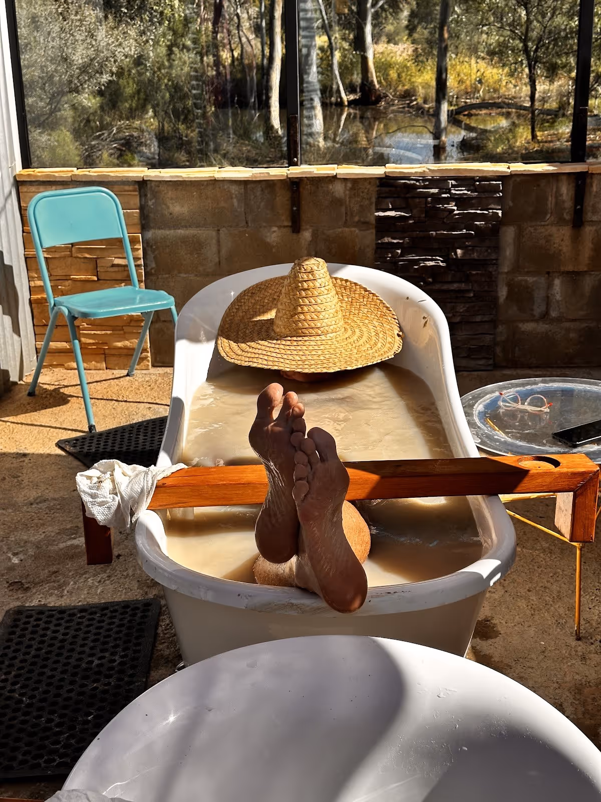 Person relaxing in a beating tub filled with mud at Eulo Artesian Mud Baths near Eulo Queensland Australia with nature view.