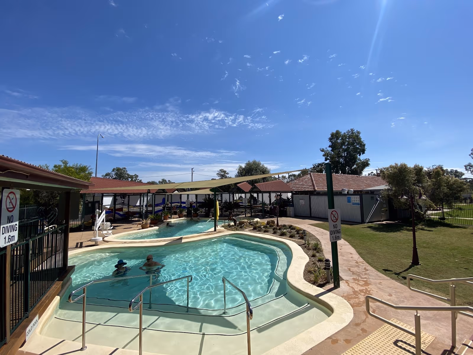 Outdoor hot spring pool with clear water and shaded seating area at Great Artesian Spa near Mitchell Queensland Australia.