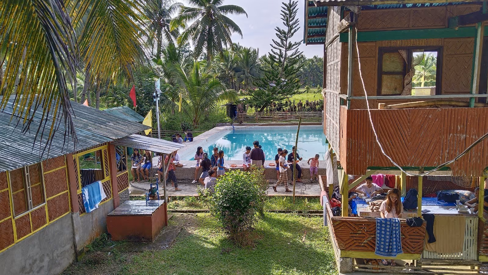 Large outdoor hot spring pool surrounded by tropical huts and palm trees at Mapaso Hot Spring near Calbayog City Philippines.