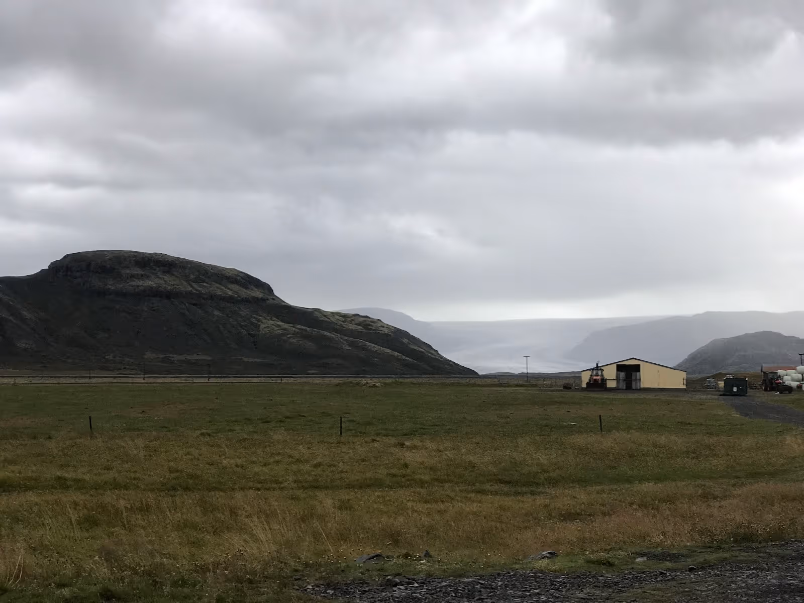 Several outdoor spa pools with people soaking under a cloudy sky near Hoffell Hot Tubs near Hofn in Iceland.