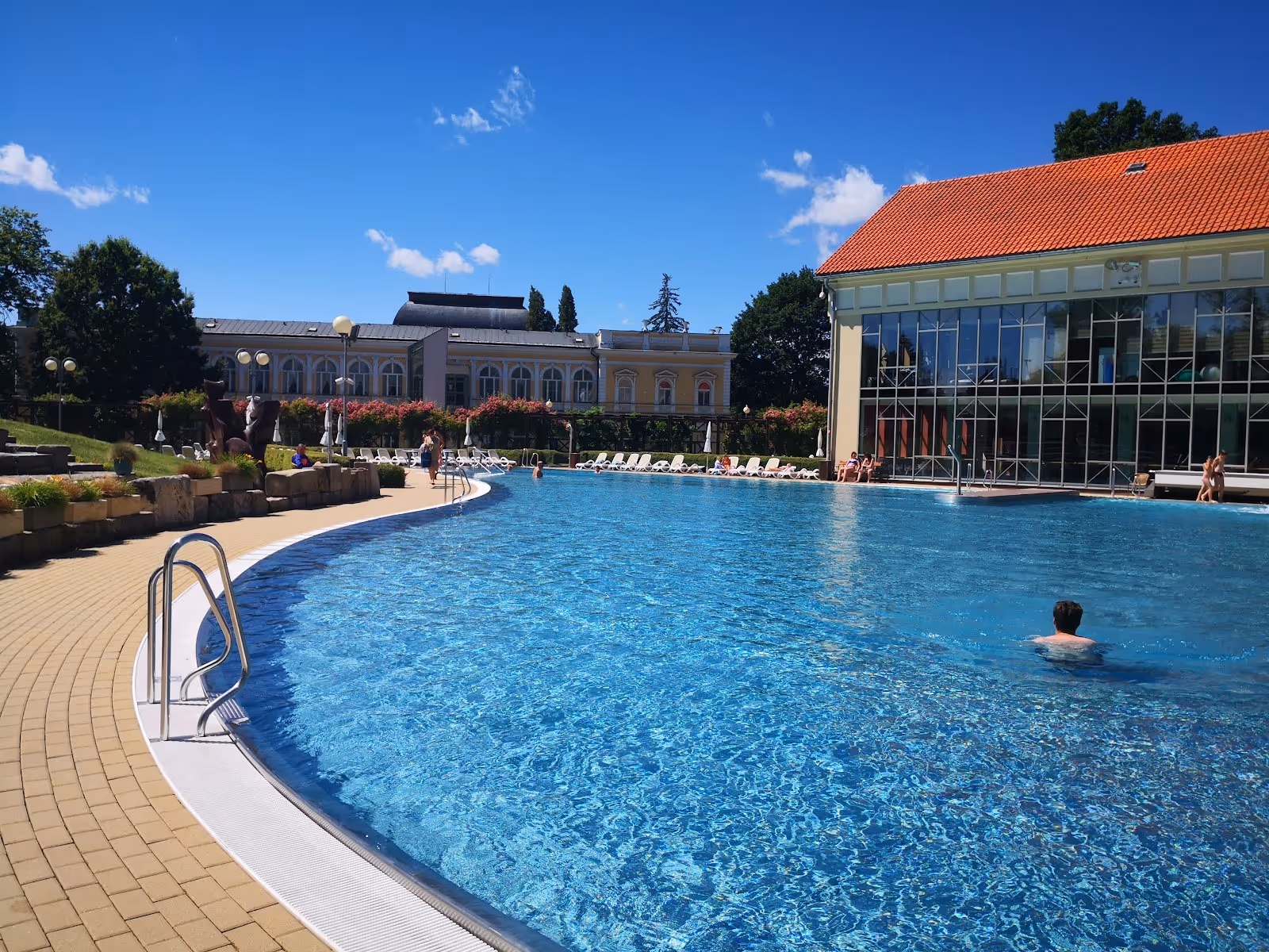 Large outdoor mineral pool with clear water and surrounding buildings at Aquaforum Frantiskovy Lazne in Frantiskovy Lazne, Czechia.