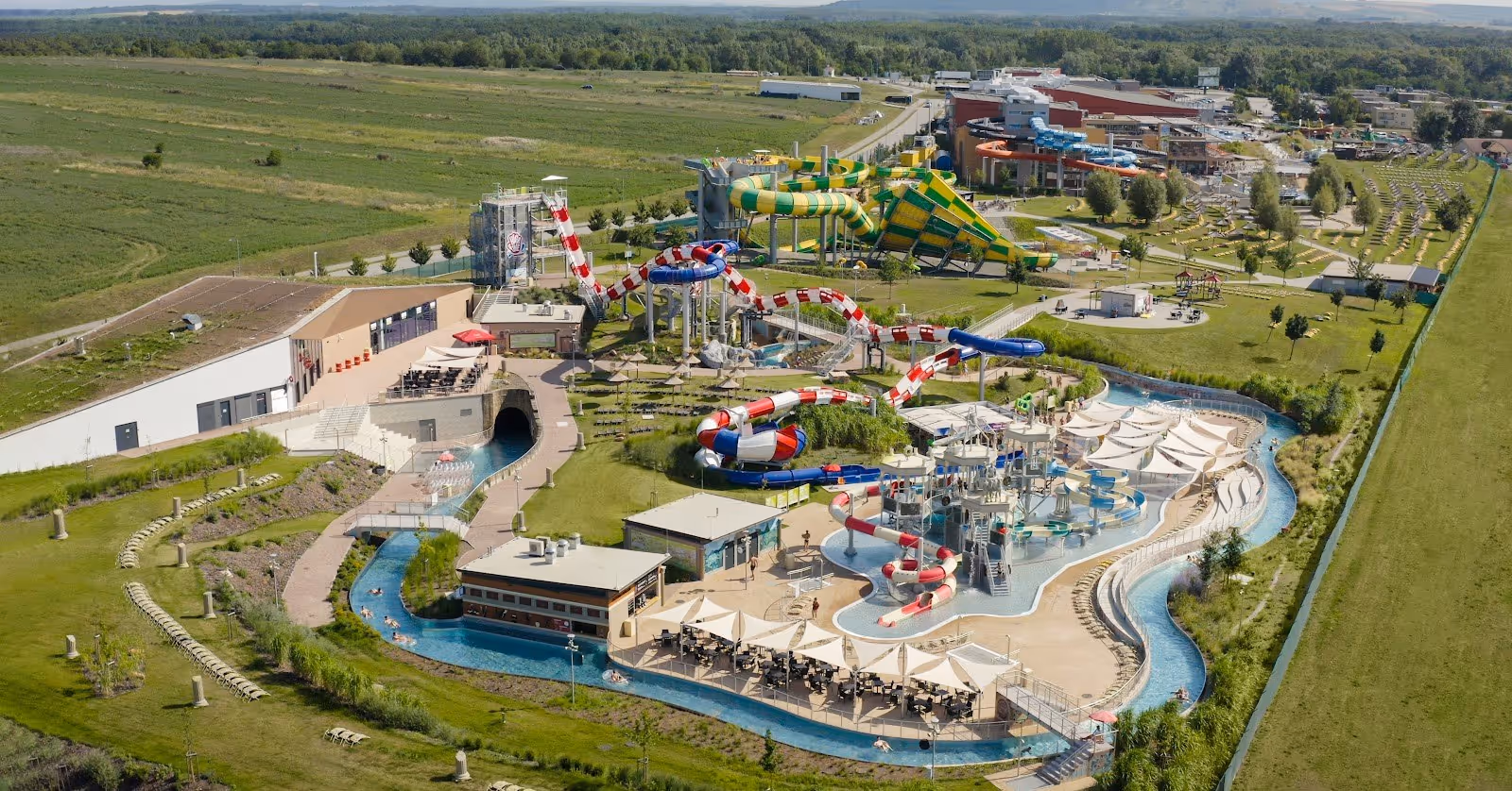 Large outdoor waterpark pools at Aqualand Moravia featuring several people enjoying sunny weather near Pasohlavky Czechia.