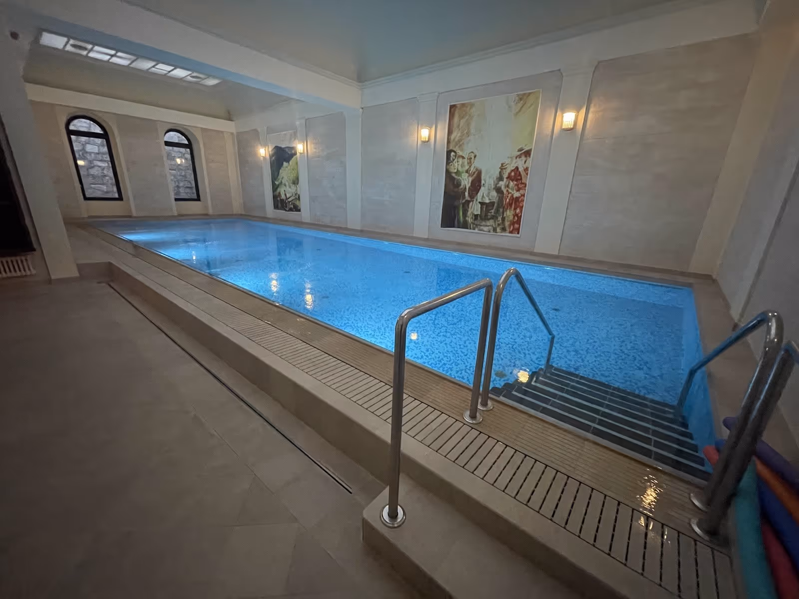 Wide angle view of Windsor SPA Hotel indoor mineral pool showing water reflections and arched windows in Karlovy Vary.