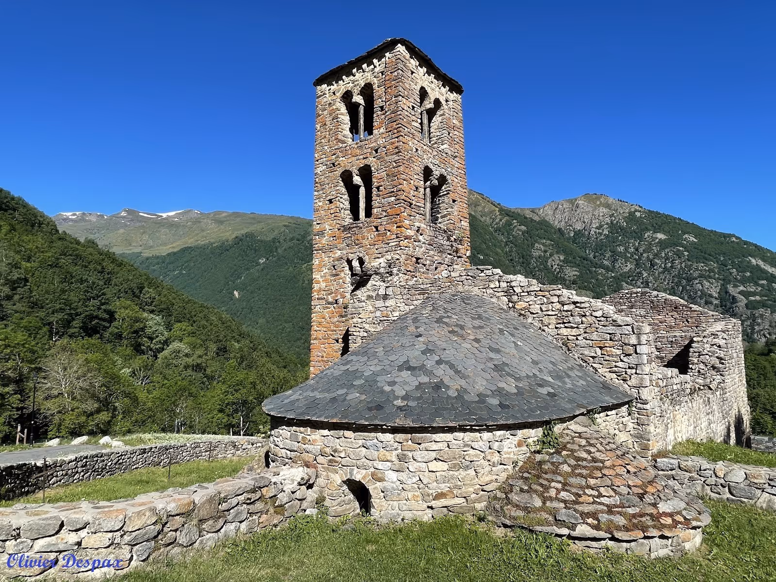 Ancient stone tower and ruins with a slate roof located in the green mountainous area near Merens-les-Vals in France.