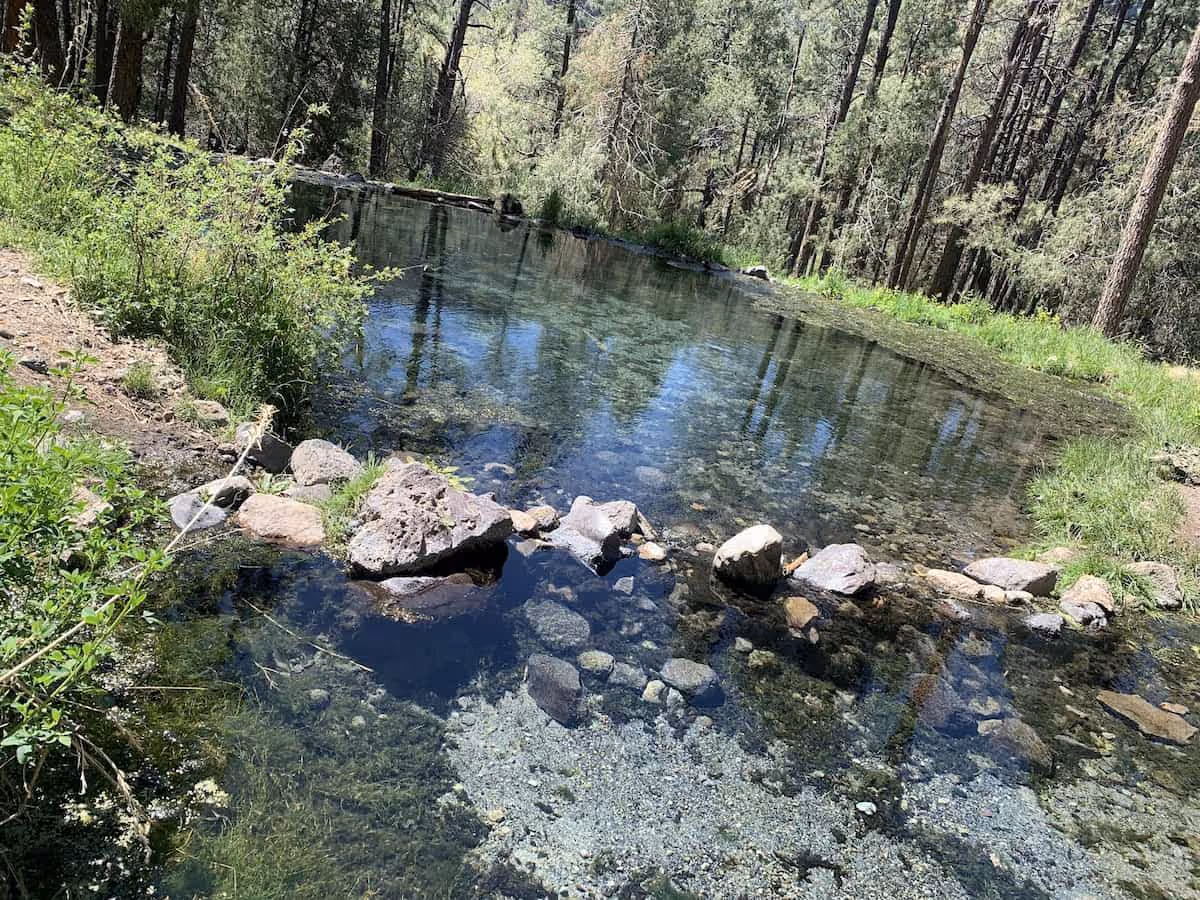 McCauley Warm Springs New Mexico - soaking pools in a forested canyon clearing near Battleship Rock