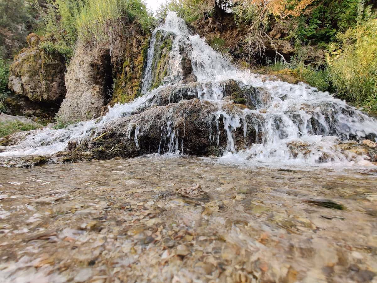 Nimrod Hot Springs, Montana - clear blue warm spring pool near Bryne fed by a rock cascade off I-90