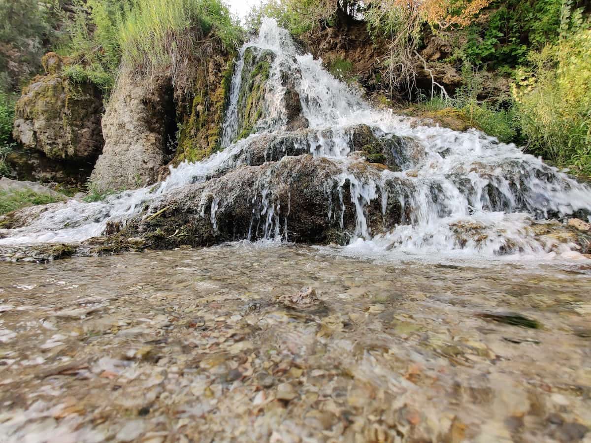 Nimrod Hot Springs, Montana - clear blue warm spring pool near Bryne fed by a rock cascade off I-90