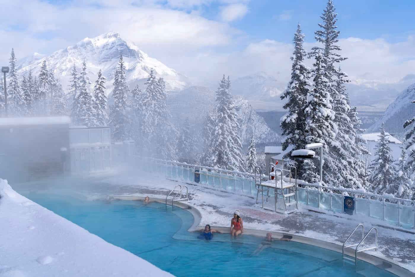 Banff Upper Hot Springs, Canada - outdoor mineral pool with steam rising, framed by Mount Rundle and the Canadian Rockies in winter snow