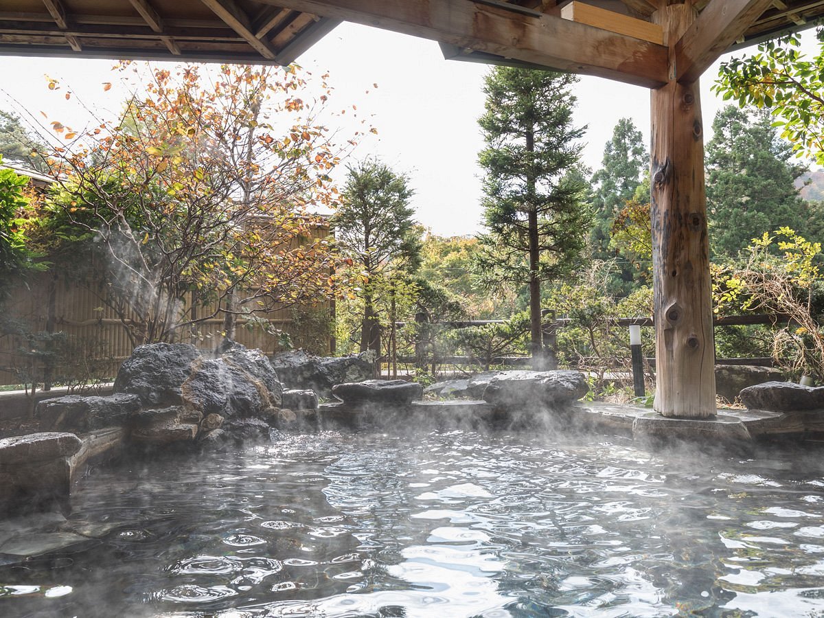 steamy indoor hot spring pool with forest views at hanamaki onsen