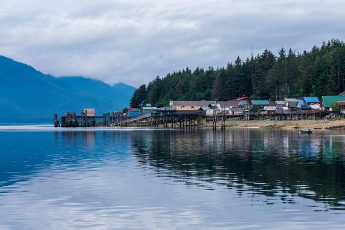 Lakefront tenakee springs town with mountain backdrop at tenakee springs, alaska