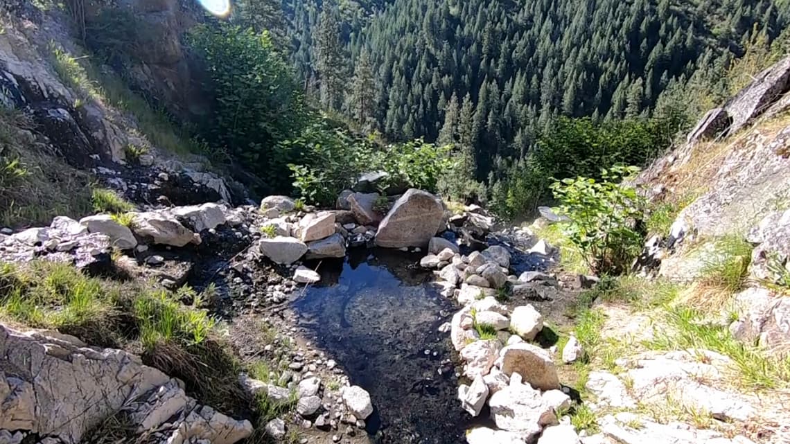 Forested hillside hot springs pool above the South Fork of the Payette River at Skinny Dipper Hot Springs in Idaho