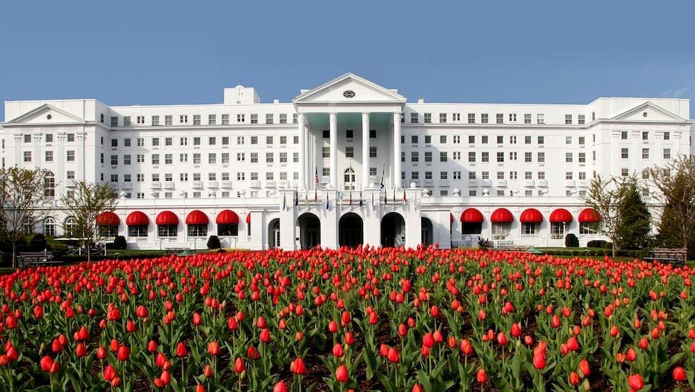 white columned grand resort building against allegheny mountains at the Greenbrier in West Virginia