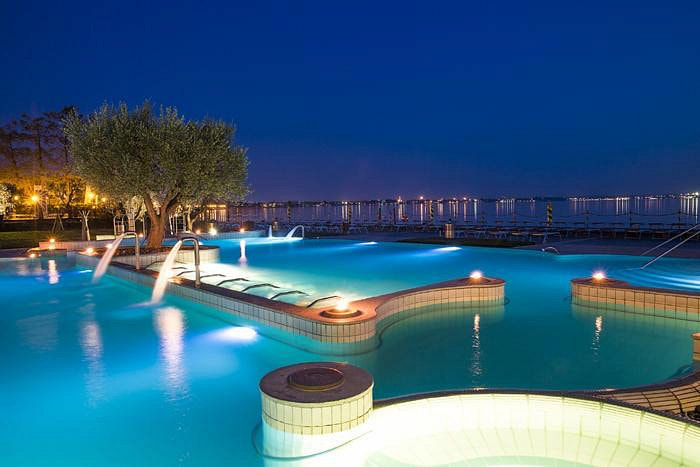Outdoor thermal pool at night with Lake garda in the background at Terme di Sirmione
