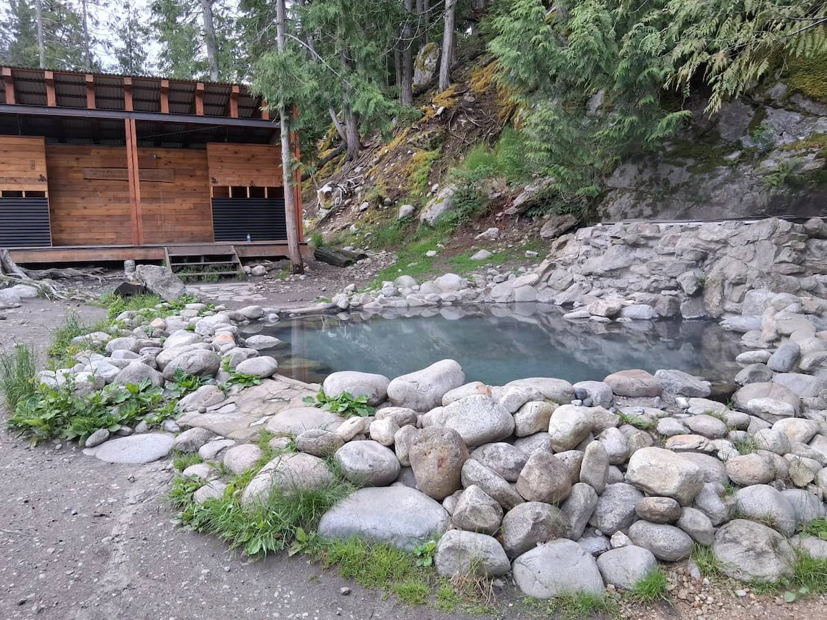 Natural hot spring pool in a forested and rocky area at halfway hot springs in canada