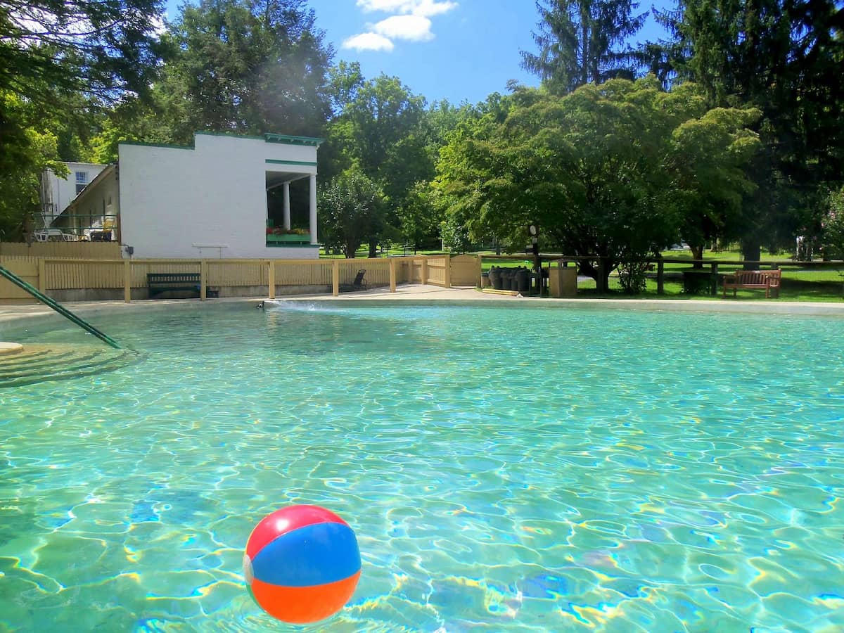 Turquoise water hot spring pool surrounded by trees at Capon springs resort in west virginia