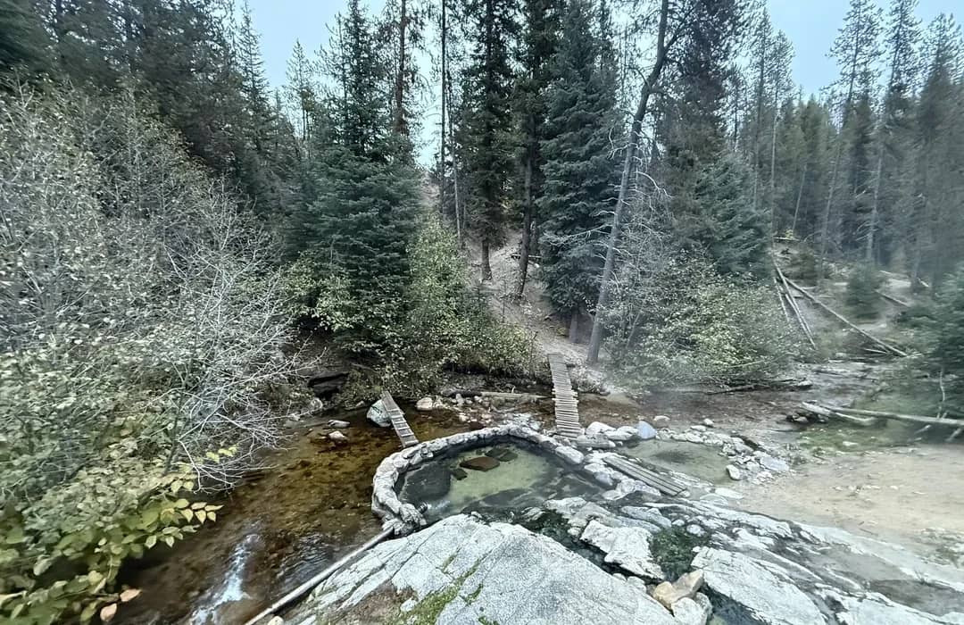 Weir Creek Hot Springs, Idaho - rock pools among cedar trees and volcanic cliffs above Weir Creek