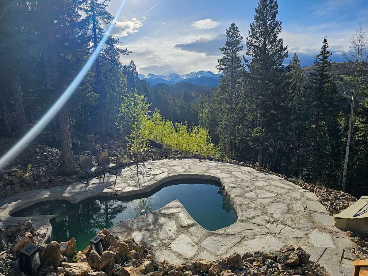 Outdoor hot springs pool with mountain valley and forest views at Raspberry Hot Springs near Denver, Colorado