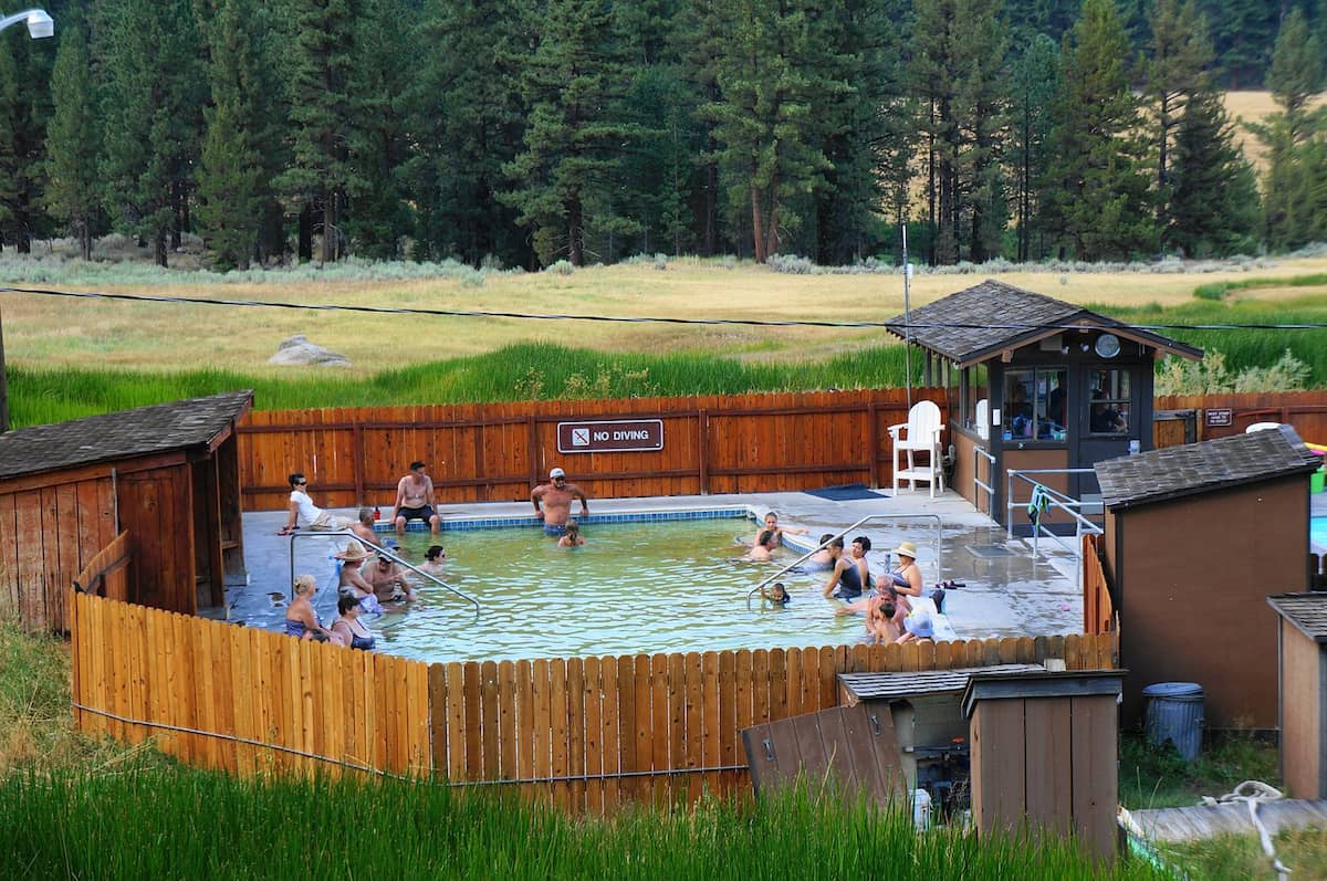 People soaking in an outdoor hot springs pool in a mountain valley at grover hot springs california