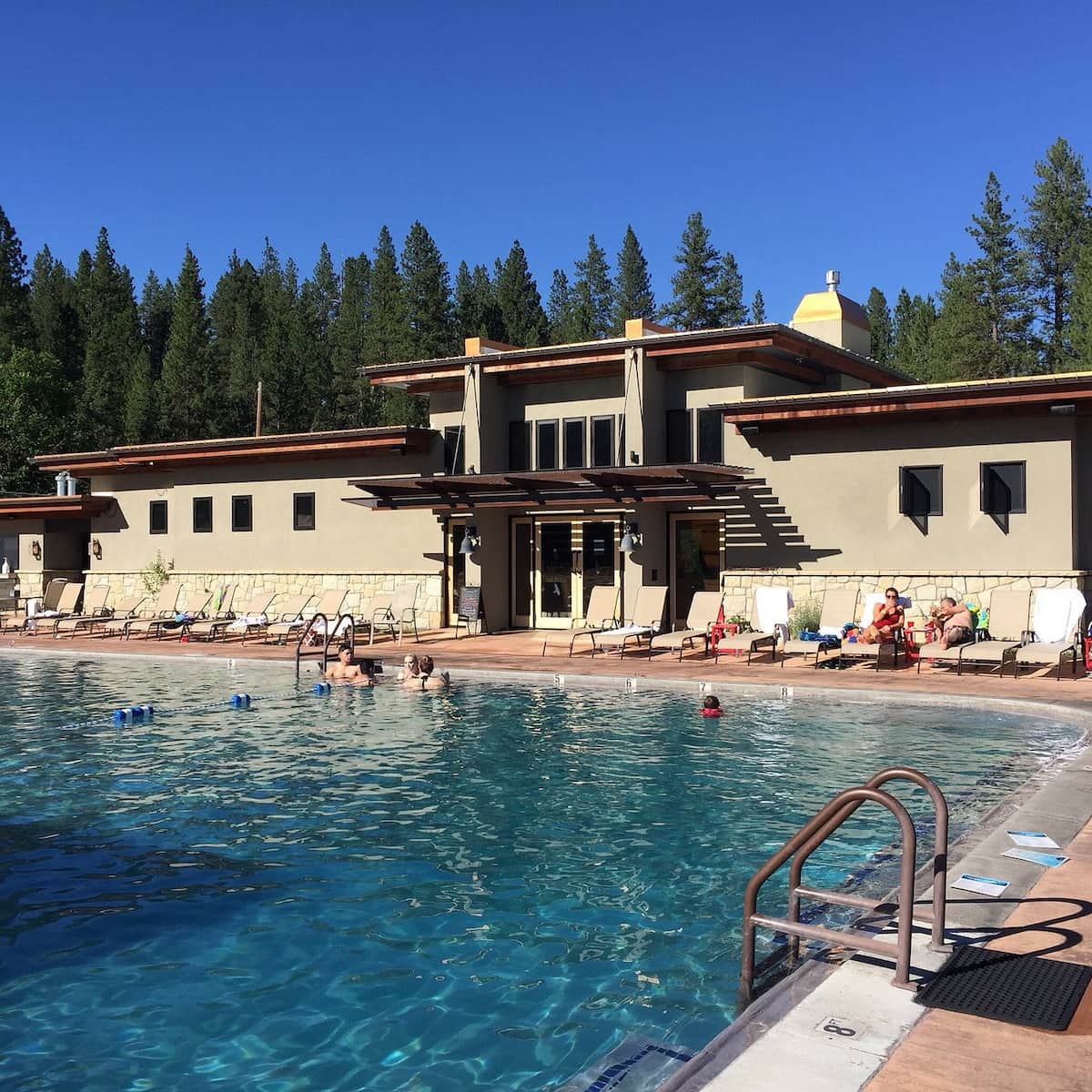 People soaking in outdoor hot spring pool with forest backdrop in the springs idaho