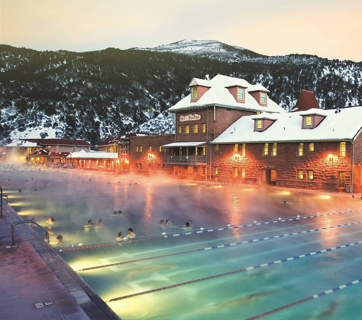 Outdoor hot spring pool and resort surrounded by a mountain valley, in the evening at glenwood hot springs colorado