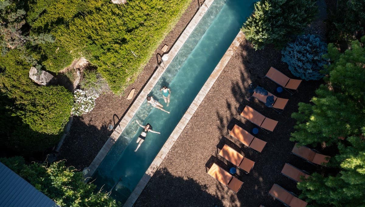 People soaking at an outdoor hot spring pool in a resort setting at ojo santa fe spa in new mexico