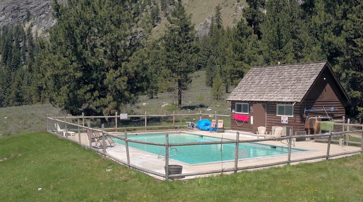 Outdoor hot spring pool and cabin house with mountain backdrop at sawtooth lodge hot springs idaho