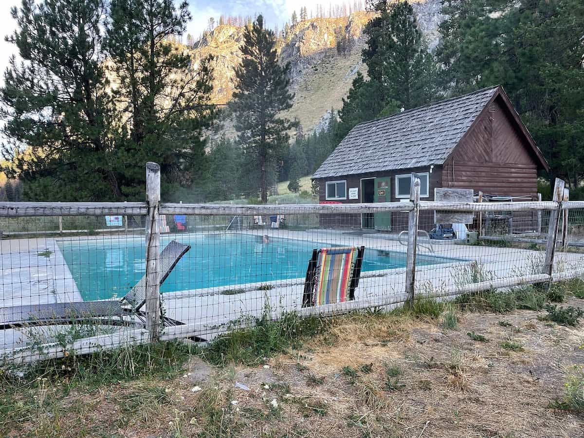 Outdoor hot spring pool and cabin house with mountain backdrop at sawtooth lodge hot springs idaho