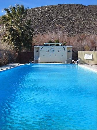 outdoor hot spring pool with desert hill in the background at shoshone hot springs california