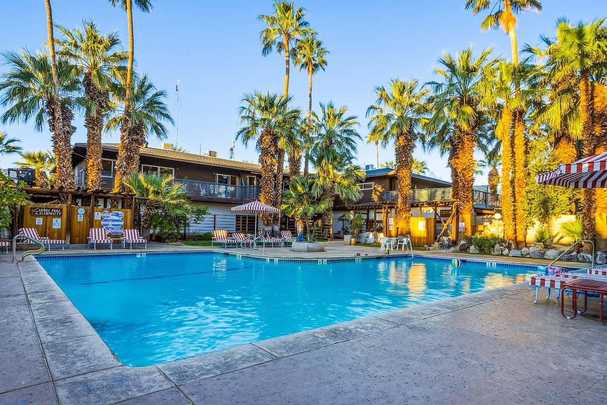 outdoor hot spring pool surrounded by lush palm trees and resort a sam's family spa california