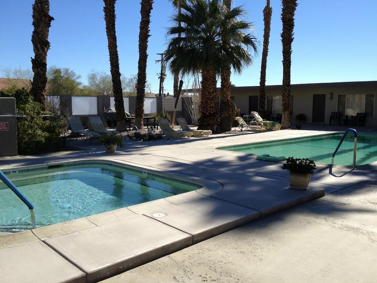 hot spring pool surrounded by palms and sun loungers at lido palms resort and spa california