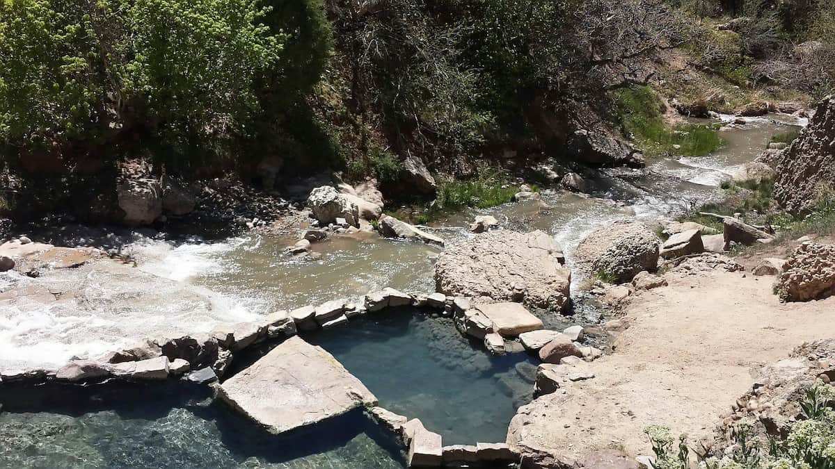 Rock lined hot spring pools beside a waterfall in diamond fork canyon at fifth water hot springs utah