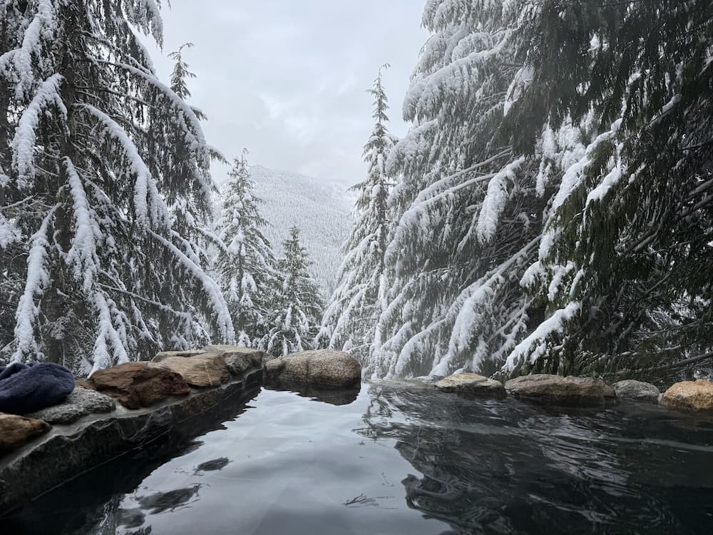 Natural hot spring pool with forest and mountain valley views in winter at scenic hot springs washington
